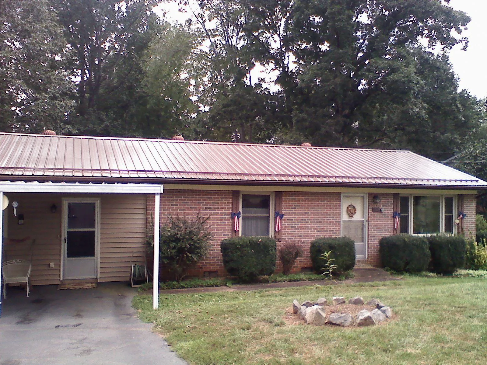 Bronze metal roof and carport on a brick ranch home — Roof Repair work by our crew in Cherry Point