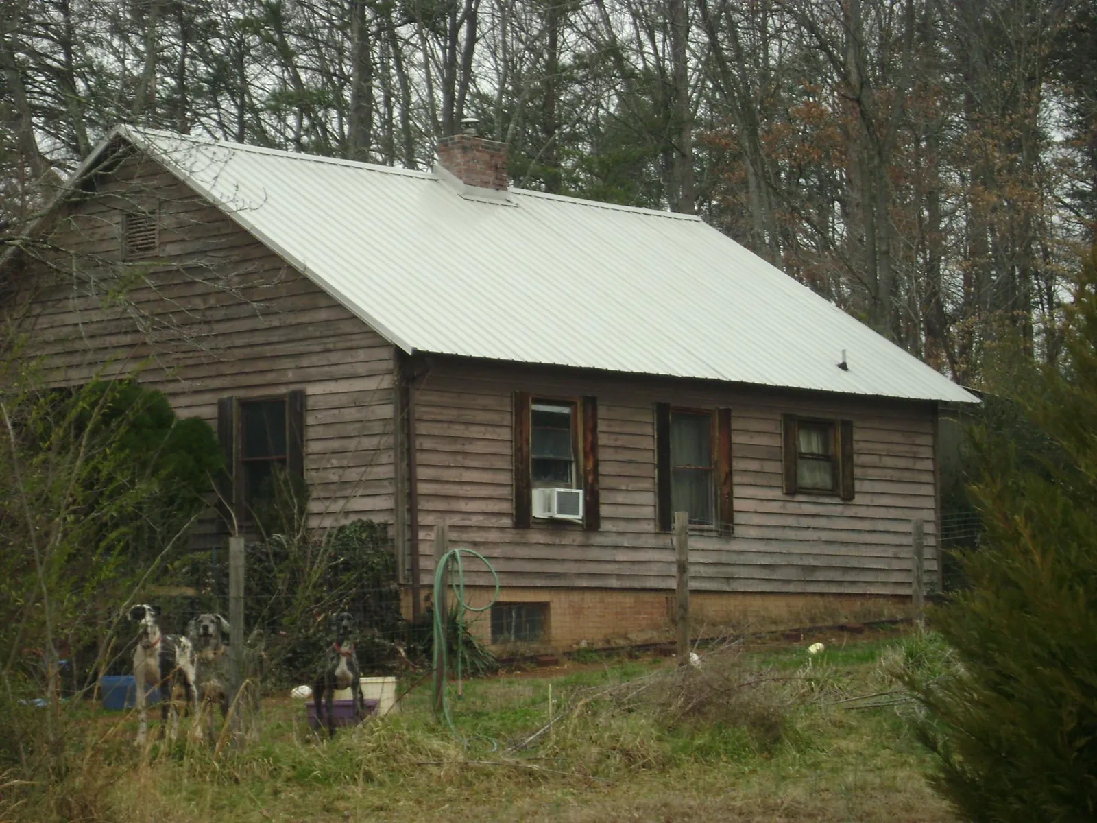White metal roof on an old wood sided farmhouse, from a Metal Roof Installation job in Cherry Point